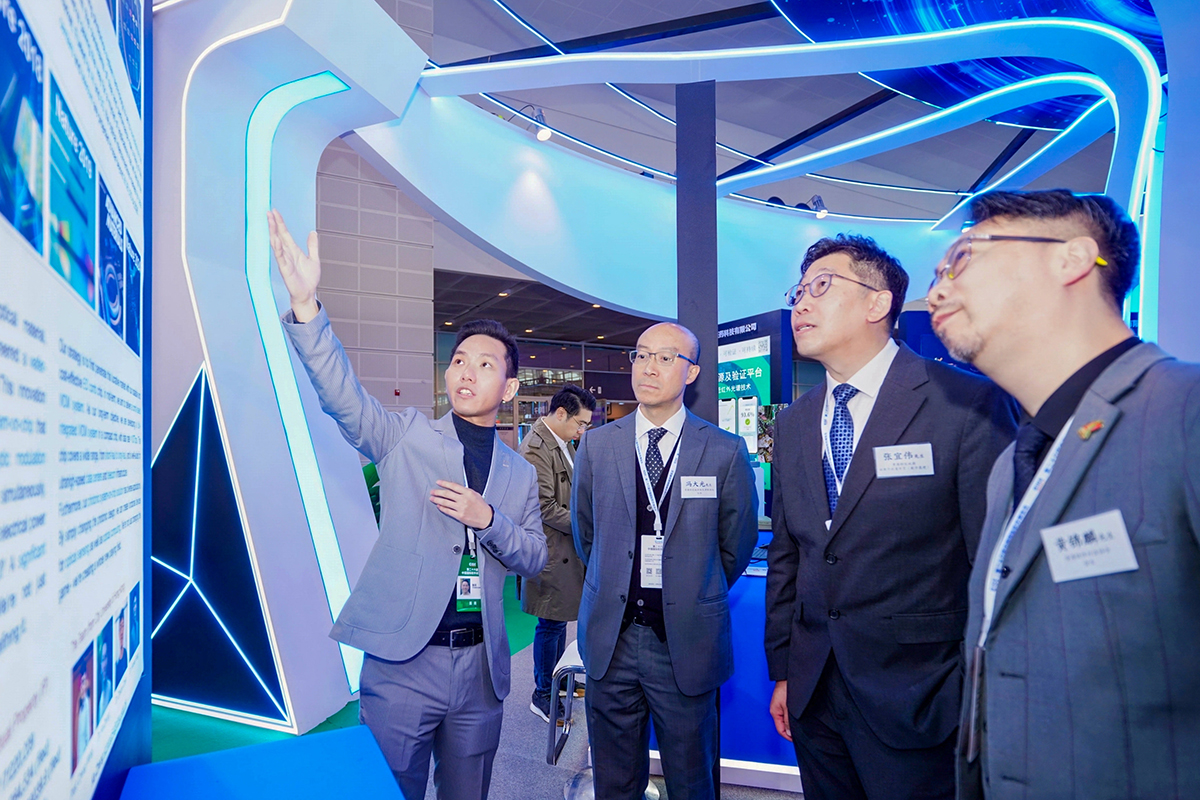 副数字政策专员(数字基建)张宜伟先生(右二);香港特区政府驻天津联络处主任冯大光先生(左二)及香港软件行业协会会长黄锦麟先生(右一)参观第二十六届中国国际软件博览会内的「香港馆」,听取参展商介绍香港创科业界的优秀产品和科技方案。