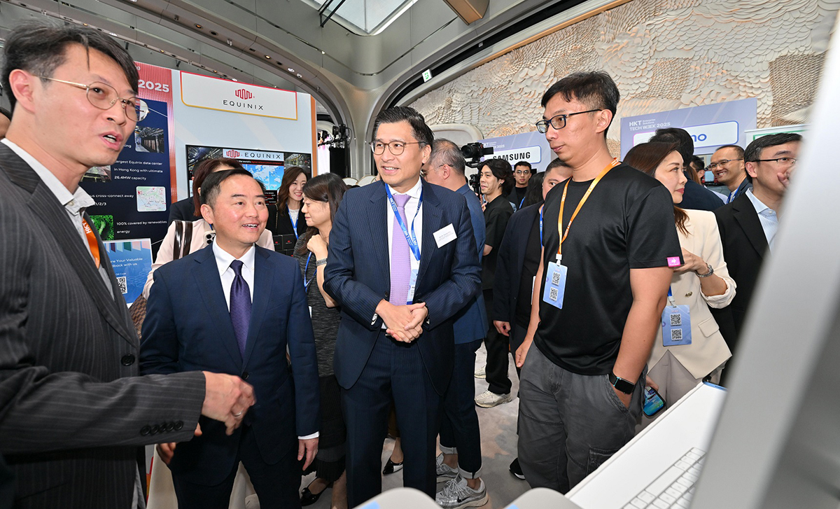 数字政策专员黄志光先生（左二）于「HKT Enterprise Solutions Tech Week 2025启动礼」之展览摊位与讲解人员交流。