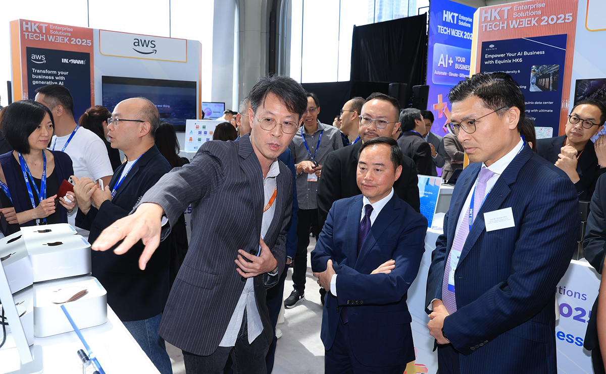 数字政策专员黄志光先生（右二）于「HKT Enterprise Solutions Tech Week 2025启动礼」之展览摊位与讲解人员交流。